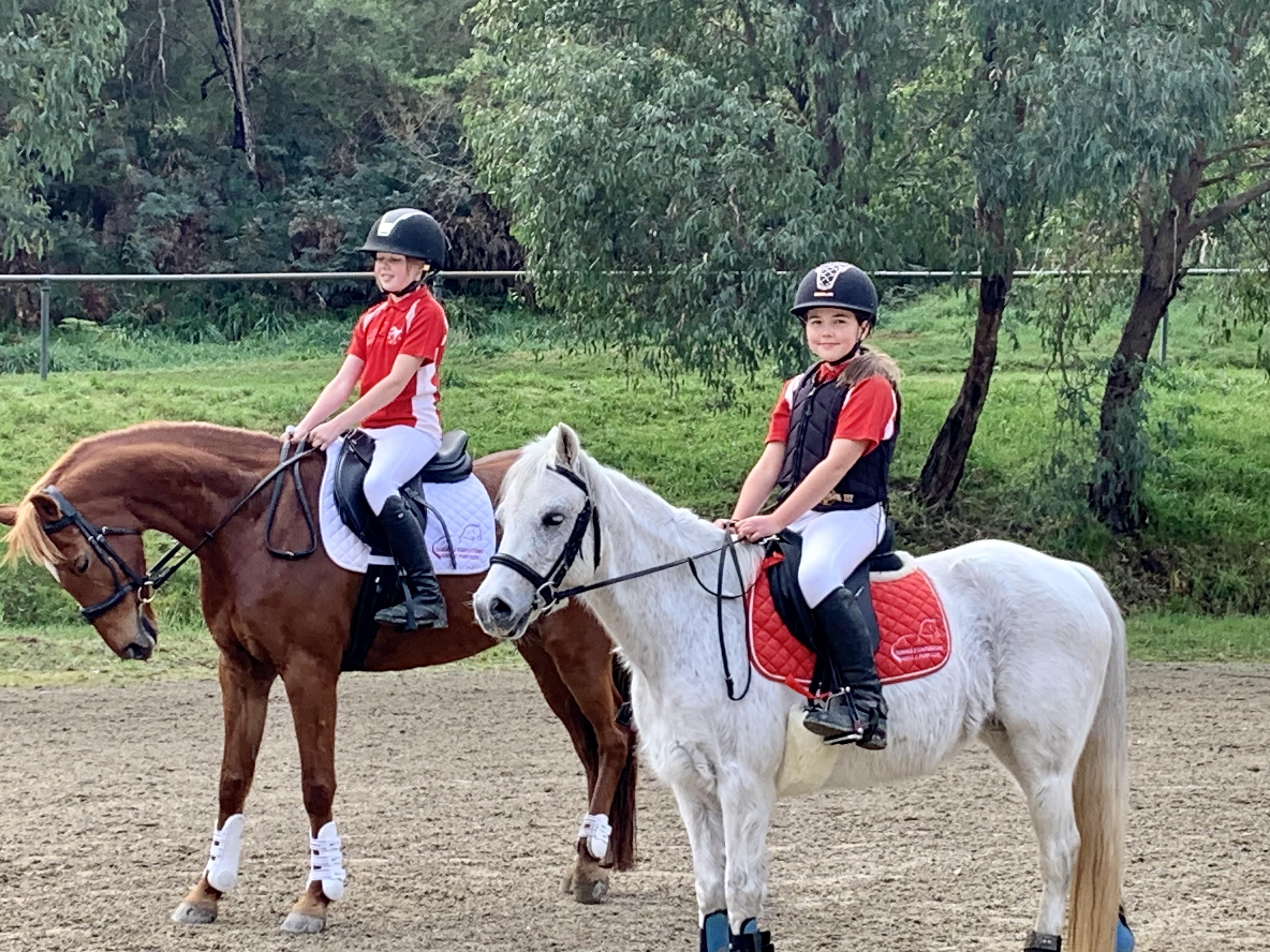 two young girls riding horses