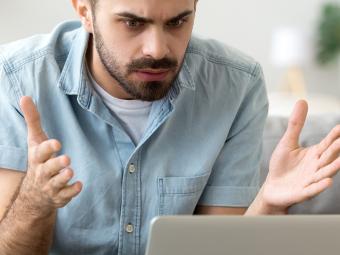 Man looking frustrated at laptop screen
